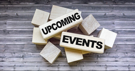 Message of upcoming events concept on blocks and wooden table.