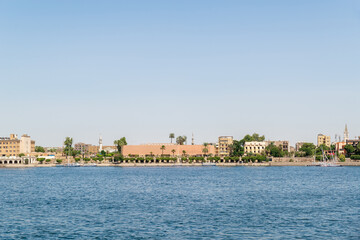 Luxor, Egypt: Panorama of river Nile in Luxor city, view from a boat. Residental buildings and sailboats.