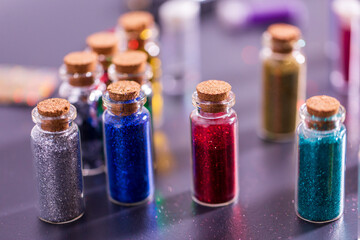 party, decoration and holidays concept - set of different color glitters in small glass bottles with cork stoppers