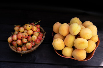 Apricots and cherries on a wooden background