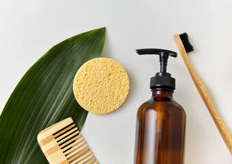 natural cosmetics, sustainability and eco living concept - wooden comb, sponge, liquid soap or...