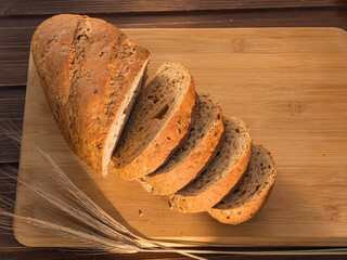 gray bread with grains on a wooden board and ears morning