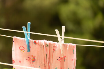 children's clothes hanging on clothesline with pegs