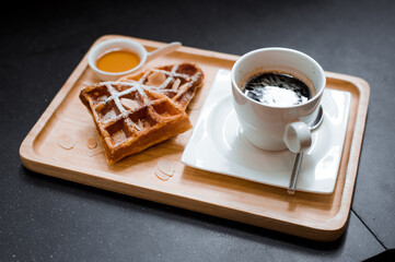 black coffee and waffle put on wooden plate