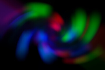 Blurred abstract gradient wave green, pink, blue, blurry christmas and holiday lights background. Multicolored, bright spiral vortex in the dark