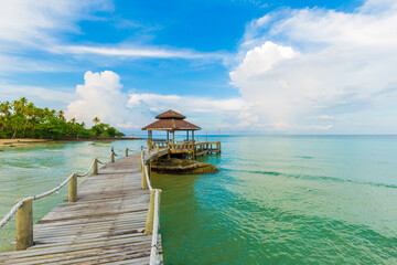 Wooden bridge to the sea beach with wooden hut blue sky