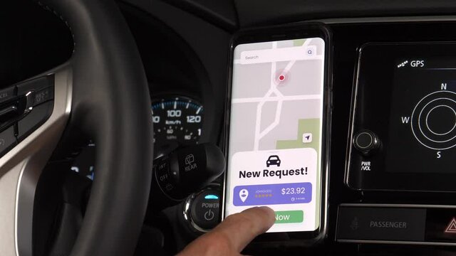 Car driver for a ride sharing service using his mobile phone to receive new requests from clients. Smartphone app notifying the vehicle driver.