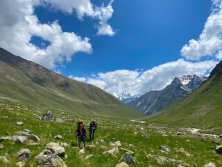 Obraz premium Two climbers are walking along a mountain trail.