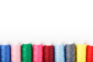 Colorful cotton craft sewing threads multicolored in a row isolated on a white background.