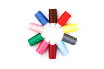 Colorful cotton craft sewing threads in flower shape isolated on white background.