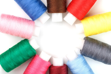 Colorful cotton craft sewing threads in flower shape isolated on white background.