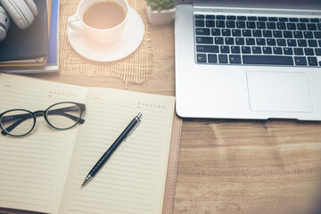 Desk for student concept. Laptop Computer for study for exam, book place on School table for student work online at home. Desktop laptop, notebook, book cup of coffee place on wooden desk.