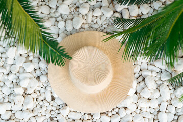 straw hut, sunglasses and palm tree leaves on the pebble beach, vacations concept.