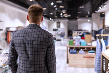 Businessman in a suit comes to a high class clothing store