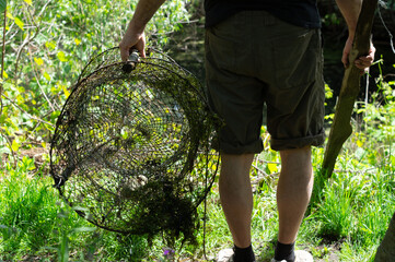 Male fisherman holds a fishing net. Poaching fishing