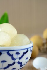 Longan in syrup and pandan leaf on wooden background. Traditional thai dessert.