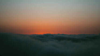 sunset over the clouds on a cliff