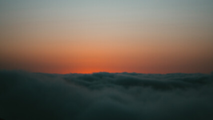 sunset over the clouds on a cliff