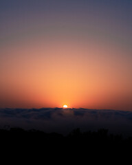 Fototapeta premium sunset over the clouds on a cliff