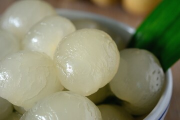 Longan in syrup and pandan leaf on wooden background. Traditional thai dessert.
