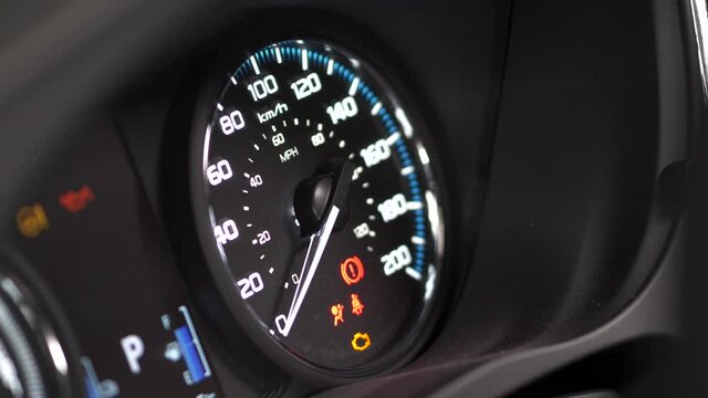 Speedometer of a car lighting up when starting the vehicle. Driver's gauges turning on.