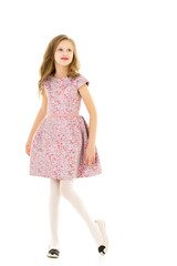 Smiling Blonde Girl with Long Hair Standing Holding Hem of her Dress.