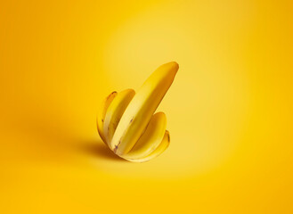 A bunch of bananas in the shape of a palm and thumb up on a yellow background. Creative concept