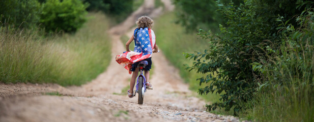 Symbol of celebration 4 fourth of july. Young Girl riding bicycle with american flag in hand - Powered by Adobe