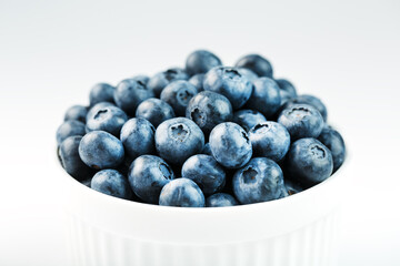 Blueberries in a white Cup on a white background. Isolate, free space