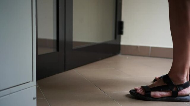 Unrecognizable male courier delivers a shopping box directly to the door. He puts the box on the floor. Contactless delivery, online shopping, new normality during the epidemic coronavirus covid-19