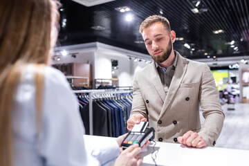 Fototapeta premium Businessman paying by credit card in a clothing store.