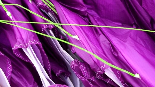 Close up of a paraglider wing equipment, showing the lines and fabric in detail (handheld)