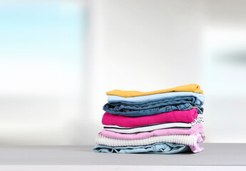Stack of colorful clothing,cotton folded clothes stacked.Apparel on table empty copy space.