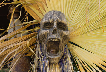 Fake mummy head used as Halloween decoration on the palm leaf background. 