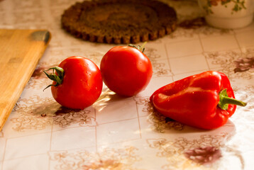 red tomatoes and red pepper lie on the table