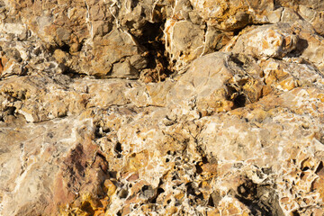 Natural cracked stone pattern. Beige rock background. Warm colored wallpaper. 