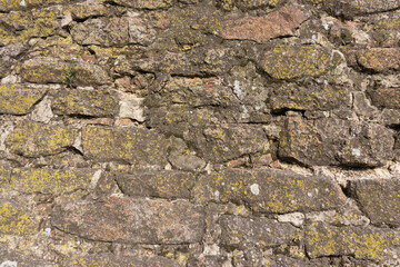Part of the old stone wall. Wall of ancient protective shelter or monastery. Stone wall background texture. 