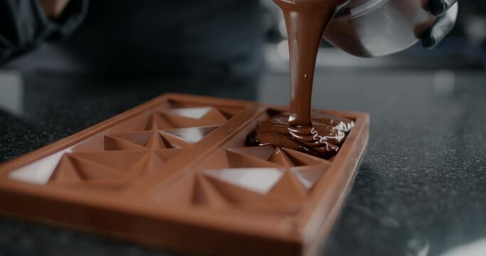 Chef confectioner makes chocolate bar - he pours hot melted chocolate to the silicone form, art of handmade chocolate, cooking desserts from chocolate and cocoa, making bars, 4k 120 fps Prores HQ