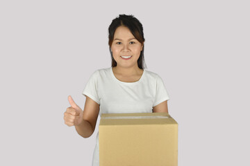 Woman wearing white shirt, holding a box with showing thumbs up.