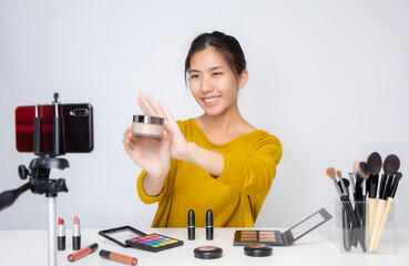 Asia woman beauty blogger does make up, reviews beauty product for video blog, gives advice to...