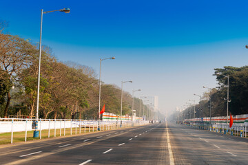 Fototapeta na wymiar View of empty Red Road in the morning with blue sky above. Shot at Kolkata, West Bengal, India.