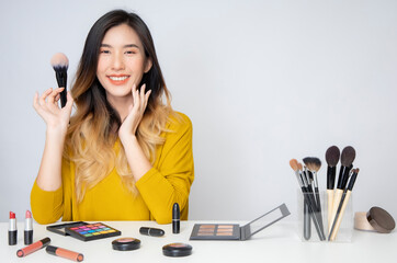 Asia woman beauty blogger does make up, reviews beauty product for video blog, gives advice to...