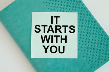  text it starts with you available written on a blue background and notepad