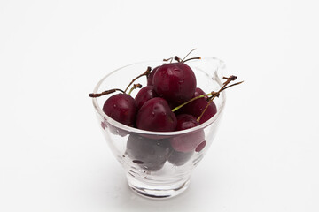 Sweet ripe cherry in glass cup isolated on whte background