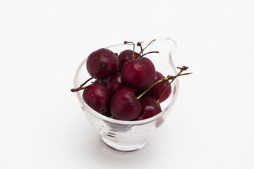 Sweet ripe cherry in glass cup isolated on whte background