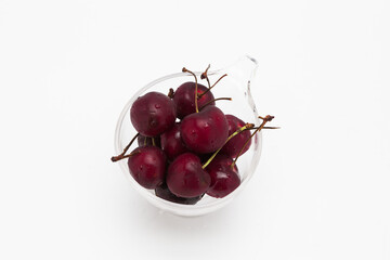 Sweet ripe cherry in glass cup isolated on whte background
