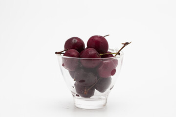 Sweet ripe cherry in glass cup isolated on whte background