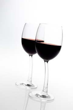 Dos copas de vino tinto, fotografía de estudio inclinada.