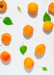 Apricots and green leaves on a white background