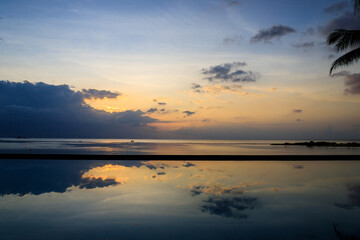 Obraz premium Blue and Orange sunset with a beautiful cloud reflexion over the water